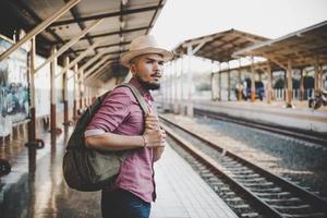ung hipster man går genom tågstationen