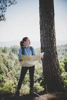 ung kvinna backpacker vandrare läsa karta vandring resa. avkopplande på semester. foto