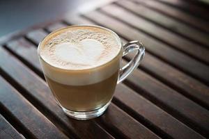 närbild av cappuccino kopp med hjärtformade mjölk mönster på café