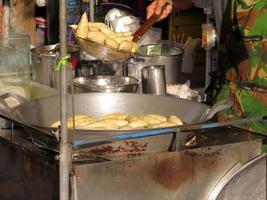 Bangkok, thailand - januari 30, 2023 de man matlagning friterad fisk boll eller kött boll i panorera på gata mat marknadsföra på chatuchak marknadsföra Bangkok, thailand. gata liv Foto och lokal- restaurang