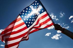 vinka USA flagga i hand mot blå himmel foto