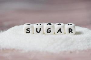socker på trä- bakgrund, vit socker för mat och sötsaker efterrätt godis högen av ljuv socker kristallin granulerad foto