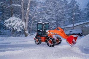 snö skyffel traktor på en tung snöig dag på heike Nej sato by i tochigi prefektur, nikko stad, japan. mjuk fokus. foto