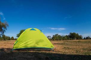 resande grön tält camping utomhus- resa. se från de tält inuti på de blå himmel Sol i de sommar landskap. under de kväll av de dag lämplig för sovande och vilar de kropp foto