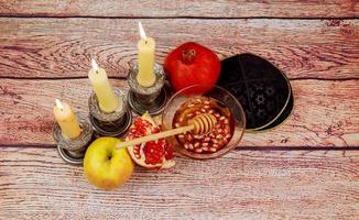 rosh hashanah jewesh holiday torah bok, honung, äpple och granatäpple över träbord. traditionella symboler. foto