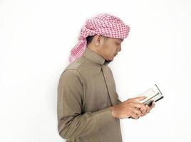 man håller och läser koranen. islamisk bakgrund foto