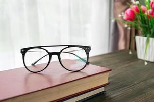 öga glasögon är placerad på böcker foto
