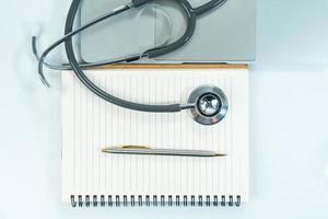 medicinskt stetoskop för läkarkontroll på anteckningsblock foto