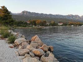 se av klippig bukt, berg räckvidd och kust städer i kroatien foto