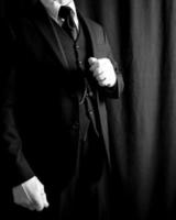 porträtt av butler i mörk kostym och vit handskar på svart bakgrund. begrepp av service industri och professionell gästfrihet. foto