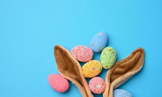 dekorativ påsk ägg och lång öron plysch kanin leksak på en blå bakgrund foto