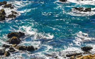 skön stenar klippor se vågor på strand puerto escondido Mexiko. foto