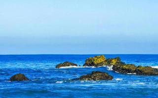 skön stenar klippor surfare vågor på strand puerto escondido Mexiko. foto