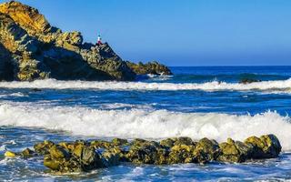 skön stenar klippor surfare vågor på strand puerto escondido Mexiko. foto