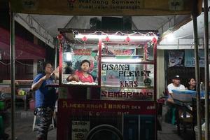 säljare av traditionell penyet bananer och en vagn på de semawis natt marknadsföra, semarang, central java, Indonesien. foto