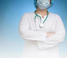 kvinna läkare i en vit medicinsk klänning står på en blå bakgrund foto