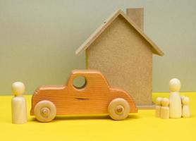 trä- hus och bil med miniatyr- familj siffror, inteckning och lån begrepp foto