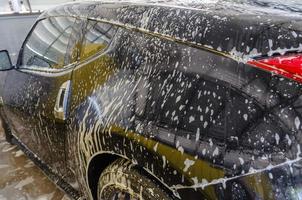 svart bil tvättas foto