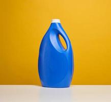 plast blå flaska med flytande rengöringsmedel stå på en vit tabell foto
