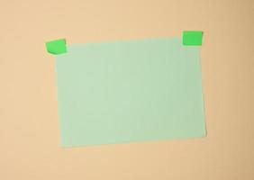 rektangulär tom grön ark av papper limmad med grön klibbig papper på ljus brun bakgrund foto
