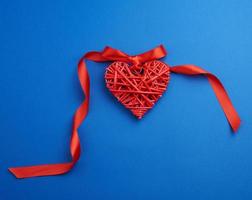 röd korg- dekorativ hjärta hängande på silke band foto