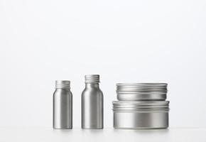 tömma silver- metall flaska för kosmetika på vit tabell. förpackning för grädde, gel, serum, foto