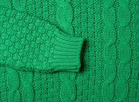 tjock sticka av en Tröja med grön trådar, full ram. mysigt och värma kläder foto