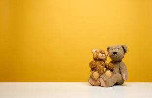 två söt brun teddy björnar Sammanträde på en gul bakgrund, barns leksak foto