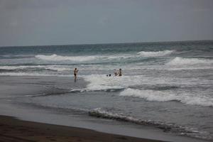 Foto av svart sand strand under de dag