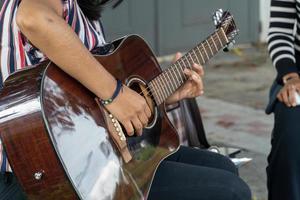 latina kvinna spelar gitarr i de gata, ung brunett kvinna, latin Amerika foto