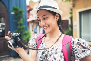närbild av en ung hipster kvinna backpacking i urban stad foto