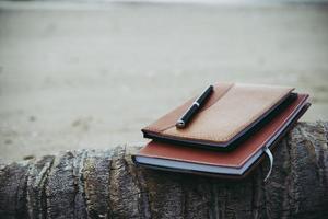 en anteckningsbok och penna på stranden foto