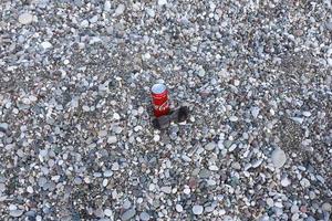 antalya, Kalkon - Maj 18, 2022 original- coca cola röd tenn kan lögner på små runda sten stenar stänga till hav Strand. Coca Cola kan och solglasögon på strand foto