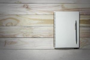 anteckningsbok och penna på träbakgrund med kopieringsutrymme foto