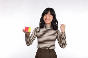 asiatisk kvinna innehav en rubik kub stående på vit bakgrund. lösning kubisk problem, problem lösning och framställning strategisk rör sig begrepp foto