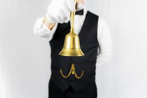 porträtt av butler eller servitör i vit handskar innehav guld klocka. begrepp av service industri och professionell gästfrihet. foto