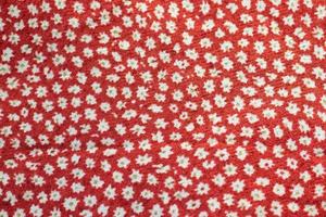 röd tyg textur med en mönster med vit blommor bakgrund foto
