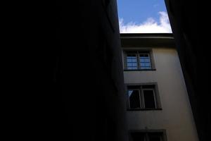 årgång hus i zurich med blå himmel och mörk gränd. foto