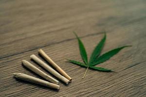 lederna med marijuana löv på woodden tabell bakgrund. foto