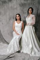 två flickor i en bröllop klänning studio porträtt på en grå bakgrund foto