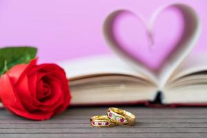 sidor av bok böjd hjärta form med bröllop ringa foto