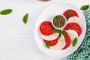 traditionell italiensk caprese sallad med mozzarella, tomat, basilika. topp se, över huvudet foto