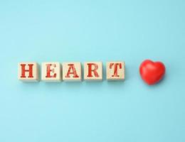 trä- block med de inskrift hjärta dag på en blå bakgrund. begrepp för hälsa vård foto