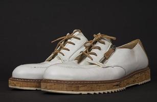 vit skor med kork sulor och brun snören. många delar med annorlunda vinklar foto