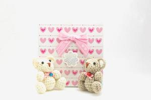 Alla hjärtans dag scen rosa hjärta mönster presentförpackning med en nallebjörn på en vit bakgrund foto