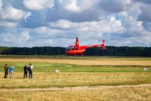 privat nöje röd helikopter på de ta av webbplats i de fält. foto