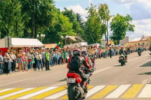 folkmassan av människor hälsar en grupp av motorcyklister på gata i stad. motorcykel parad på sommar solig dag. foto