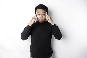 en porträtt av ett asiatisk man bär en svart skjorta isolerat förbi vit bakgrund utseende deprimerad foto