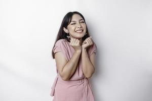 en porträtt av en söt asiatisk kvinna klädd i rosa, och känsla upphetsad och isolerat förbi en vit bakgrund foto