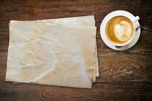 gammal papper och kaffe på trä tabell med Plats. foto